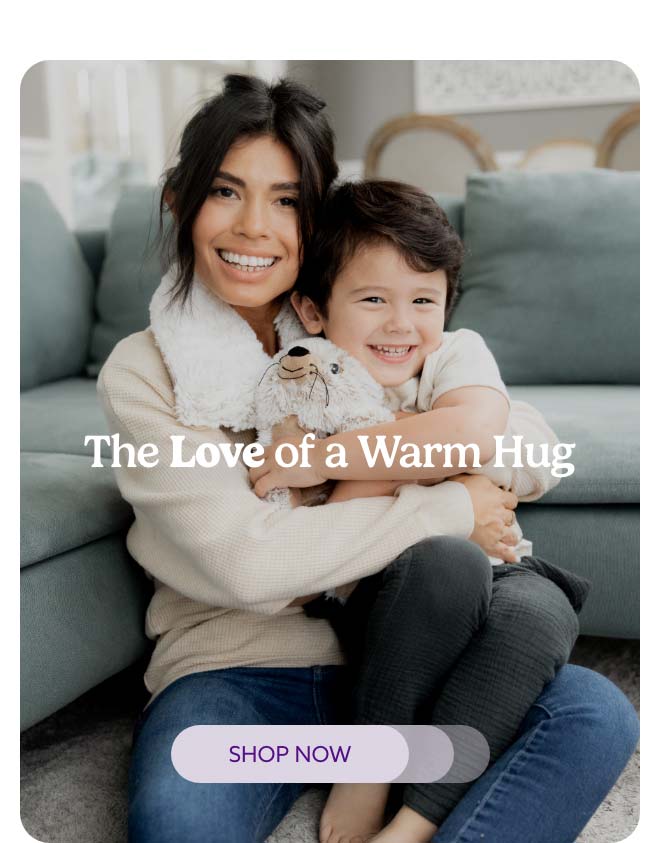 A woman and a little boy hugging Seal Warmies. Shop Now.