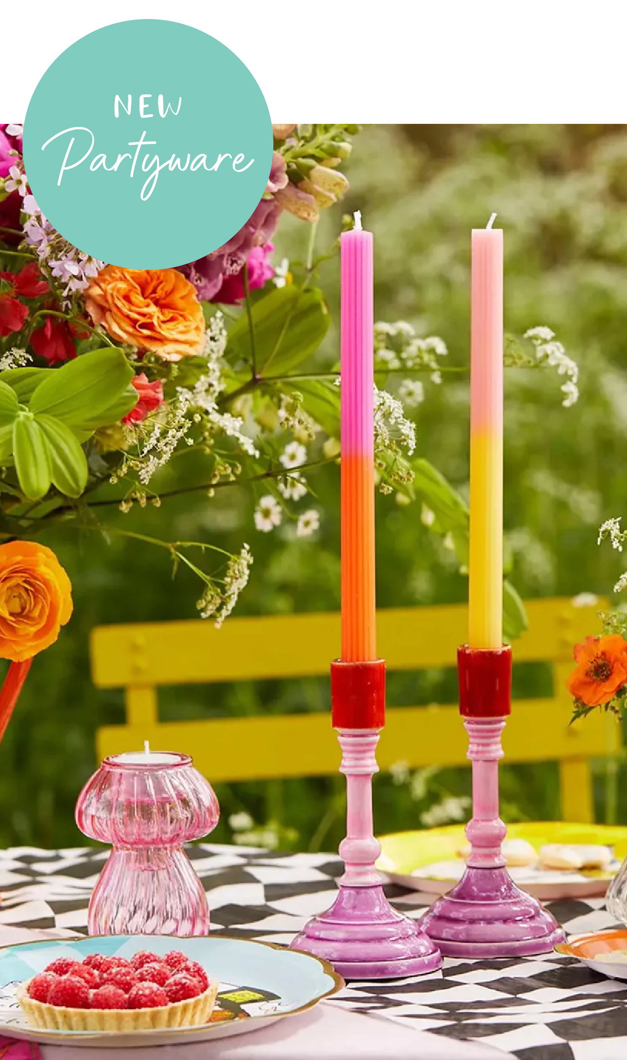 Colourful candles and bright table styling for partyware displayed in a vibrant garden setting