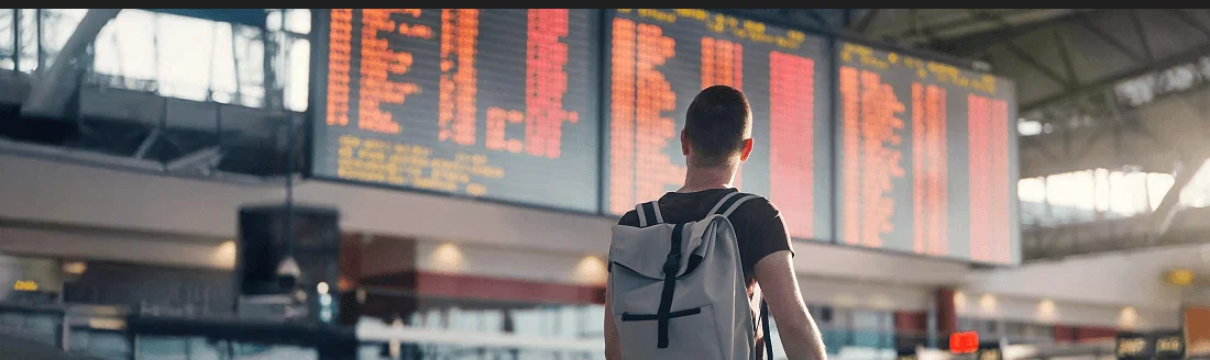 A traveller checking a departures board at an airport.