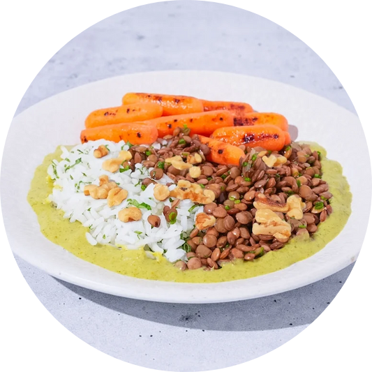 White rice, lentils, and roasted carrots in a puree on a white plate