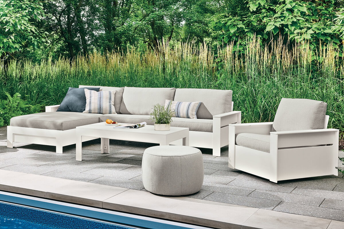 Rayo sectional with chaise and chair arranged around a table on a poolside patio.