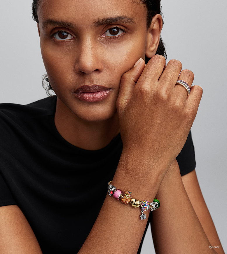 Model wears Disney Pets stacked charm bracelet
