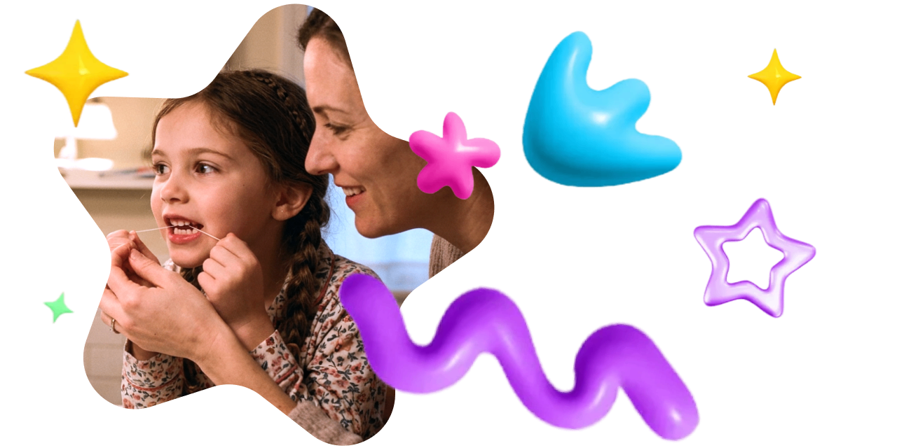 A mother helping her young daughter floss.