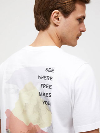 A man seen from behind wearing a white t-shirt with a printed design on the back.