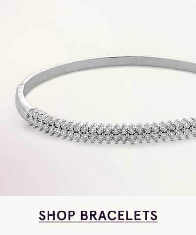 Silver bangle featuring front half with two parallel rows of round diamonds. Click here to shop bracelets