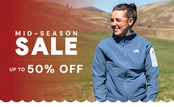 MID-SEASON SALE: UP TO 50% OFF. A woman in the hills, wearing The North Face Women's Hybrid Tek Approach Hooded Jacket in Grey.