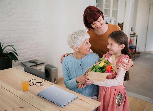 Image of young mother bringing her daughter to see her grandmother and to give her flowers, smiling and bonding.