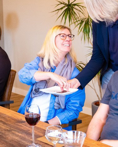 Frau beim Pralinen-Tasting bekommt eine Praline gereicht