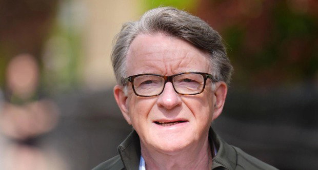 A close-up of Peter Mandelson, who has short grey hair and wears glasses and a dark green jacket.
