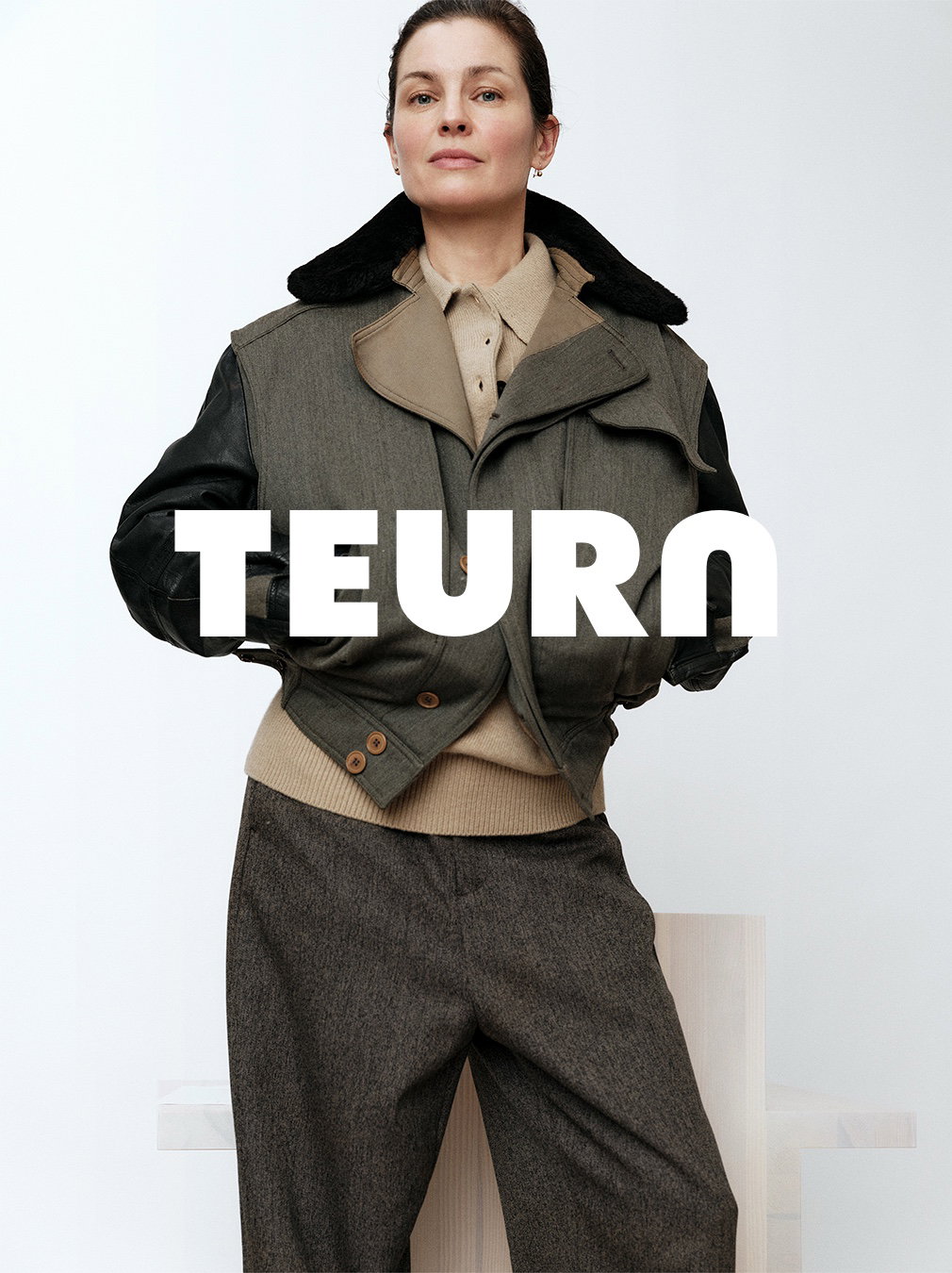 a woman in a jacket and pants is posing for a picture