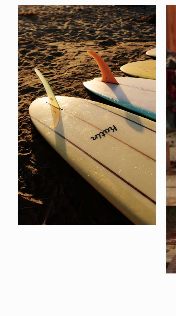 Surfboards laid out on the beach at sunset
