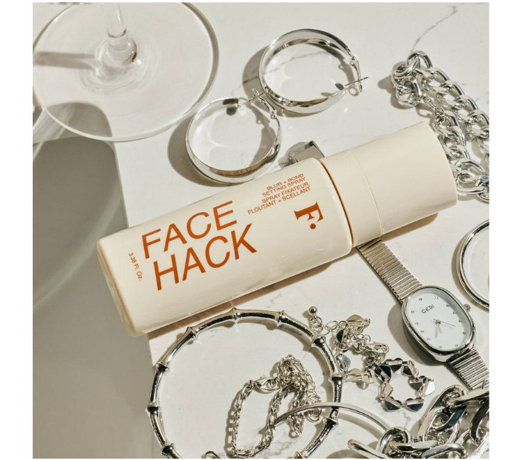 face hack setting spray on a table with silver jewelry