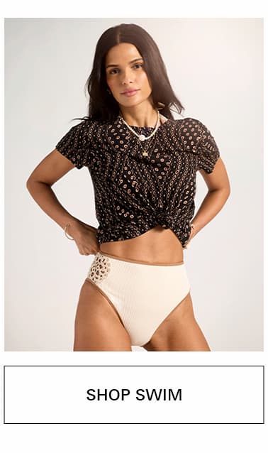 A woman wearing a perfect tee and bikini bottoms linking to swim