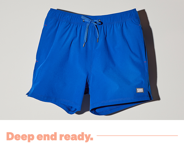 Cobalt blue SAXX swim shorts against a light grey background with "Deep end ready" text.