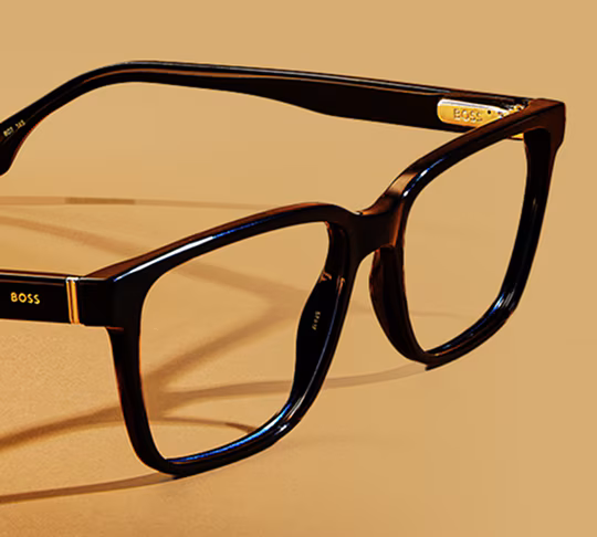 Dark-framed, rectangular Premium Designer eyeglasses on a light brown background