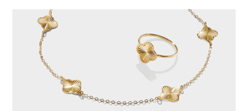 Gold necklace and ring set featuring clover-shaped motifs with textured detailing.