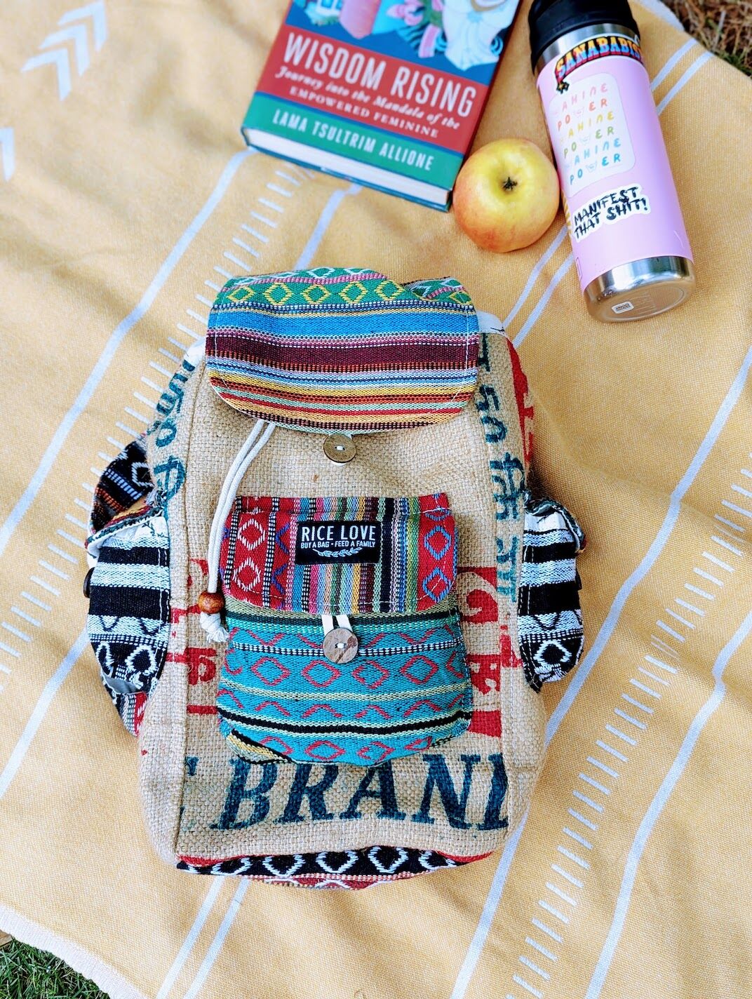 mini agra special backpack on a towel with a book and a water bottle