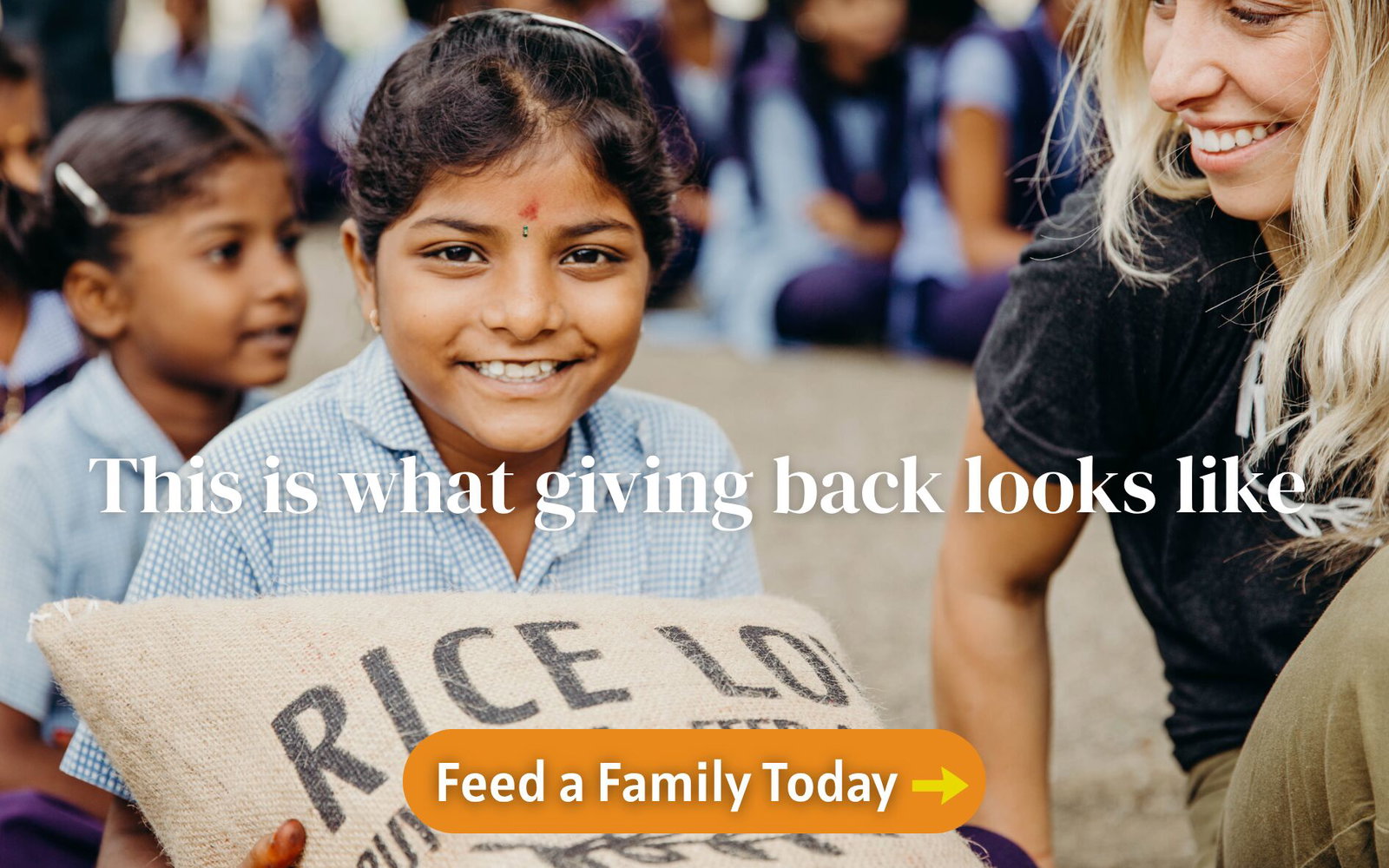 a little girl receiving a sack of rice from Rice Love