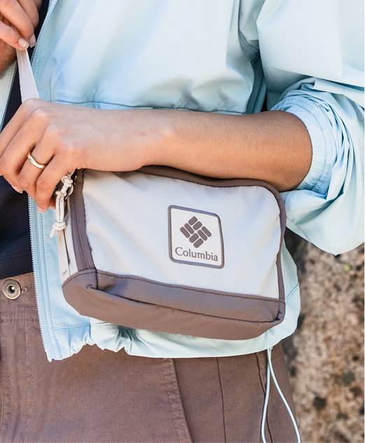 Close-up of a woman's cross-body bag with a big Columbia logo on it.