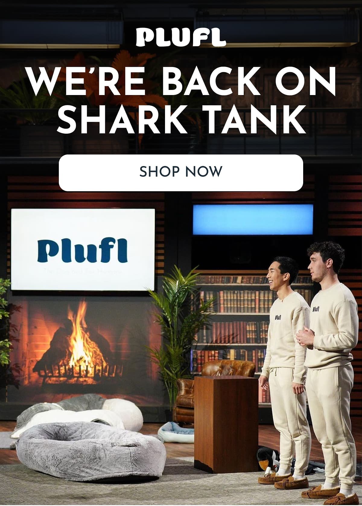 Two people in matching outfits stand next to a cozy fireplace and a large bean bag.