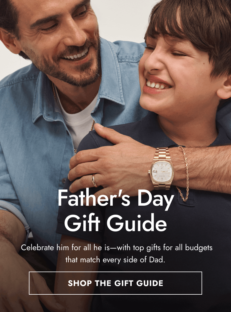Father and son embracing. Father wearing gold watch and gold bracelet. Father’s Day Gift Guide. Click shop the gift guide.