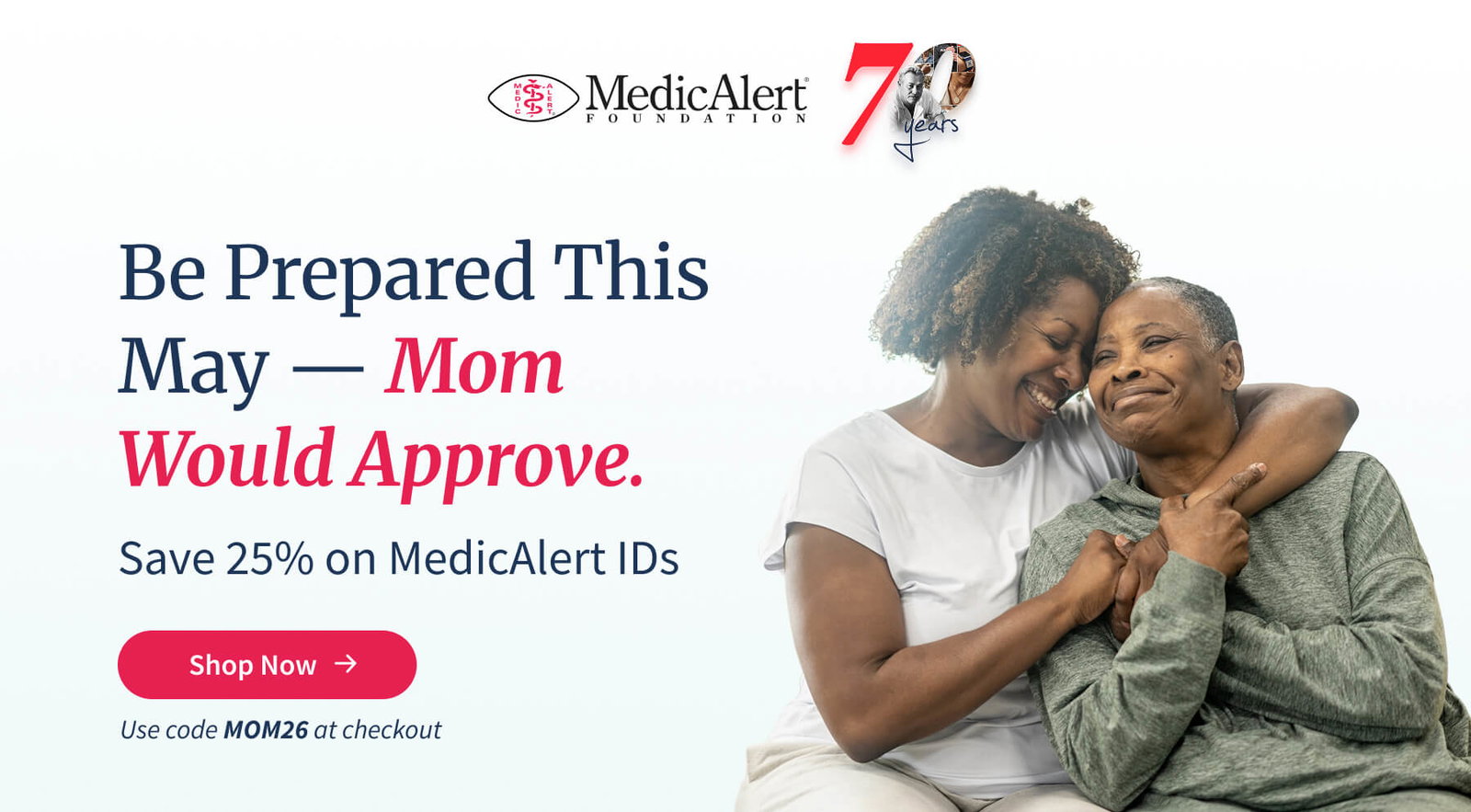 Promotional image for MedicAlert Foundation's 70th anniversary sale. The main text reads 'Be Prepared This May — Mom Would Approve. Save 25% on MedicAlert IDs'. There is a red button labeled 'Shop Now'. Below the button, text specifies, 'Use code MOM26 at checkout'. The image shows a portrait of two smiling African American women, a younger woman embracing an older woman.