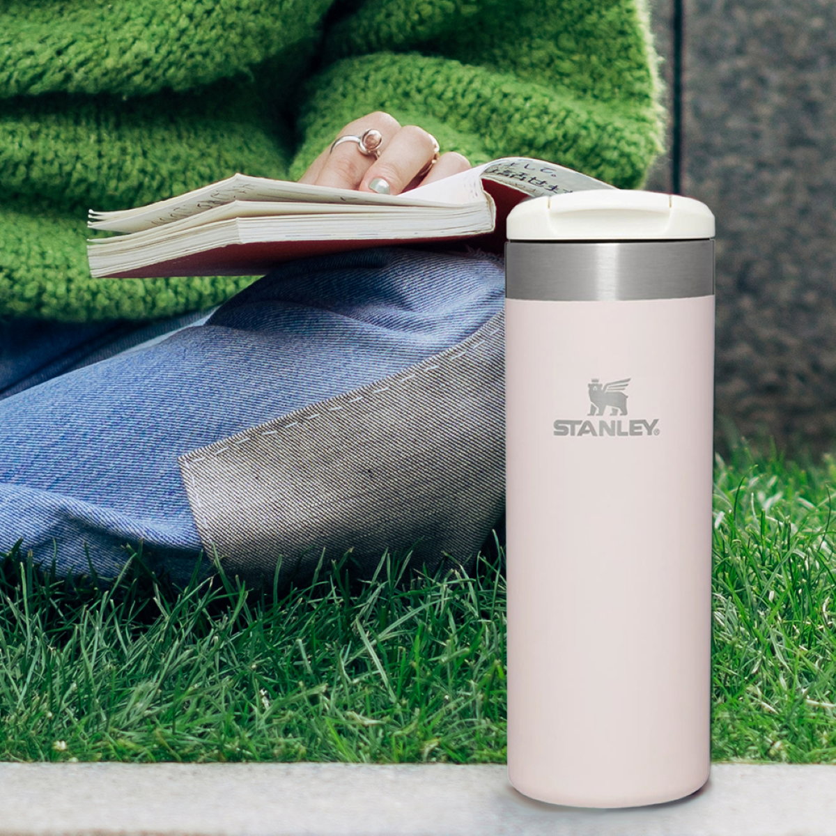 Text reading "Sip and Go" overlays image of pink hammered Stanley Travel Mug