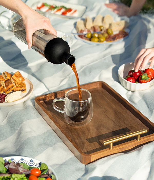 Image of summer picnic with Cold Brew Coffee bottle being poured into glass mug