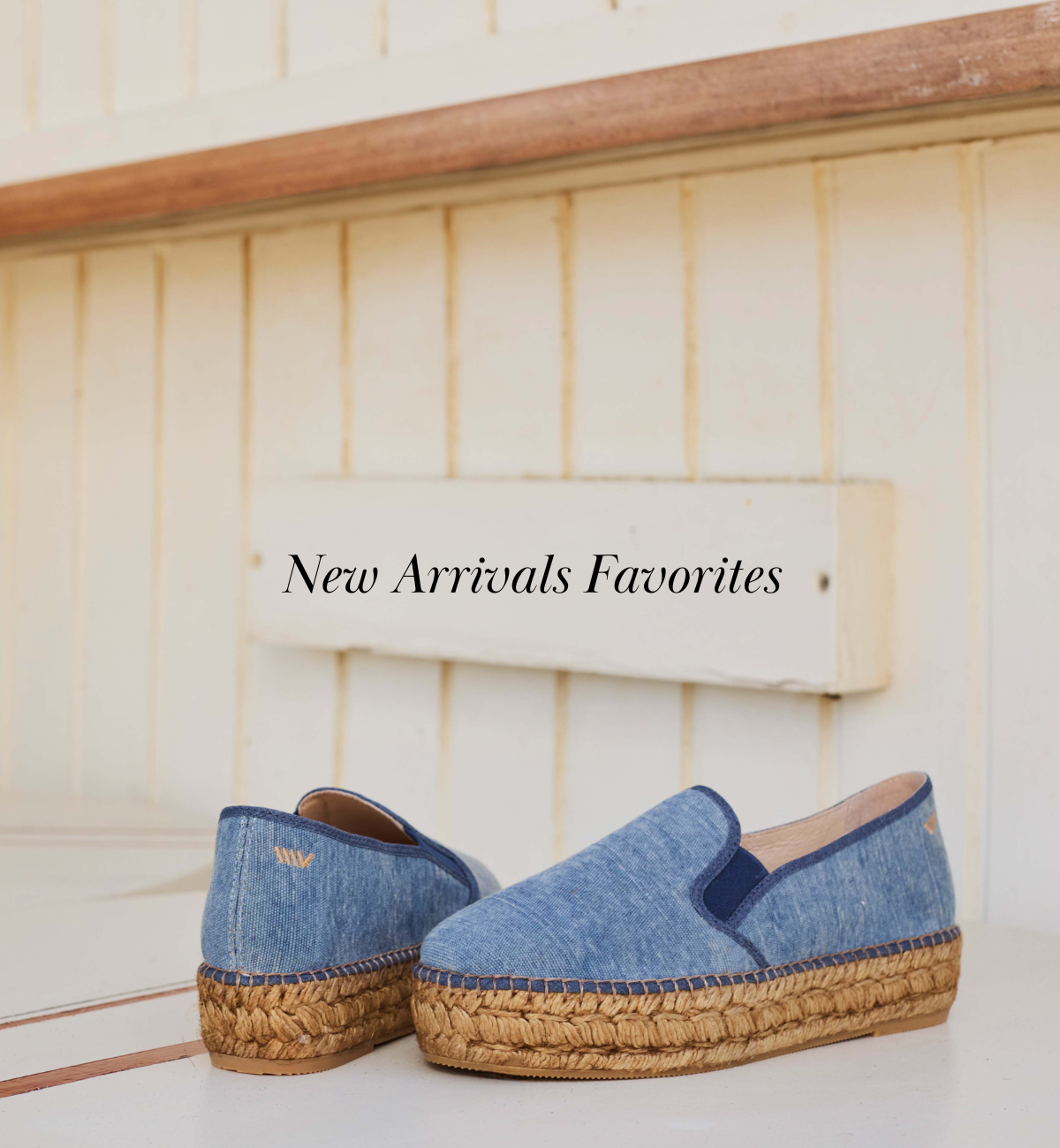 Denim blue canvas platform espadrille flats displayed on a sunlit wooden bench with New Arrivals Favorites editorial styling.
