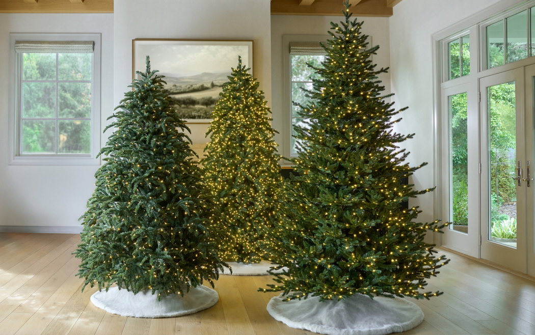 Variety of prelit Christmas trees displayed in indoor setting