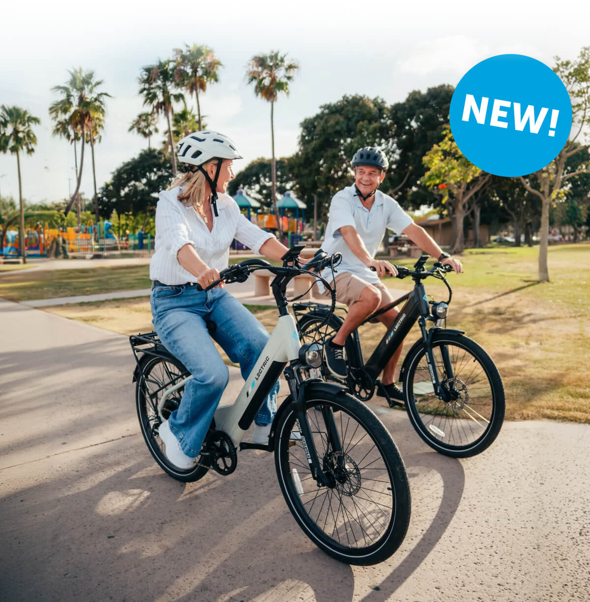 A man and woman riding XPress2 eBikes through a park