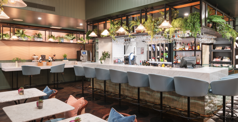 A white marble bar top with high barstool seating for a crowd.