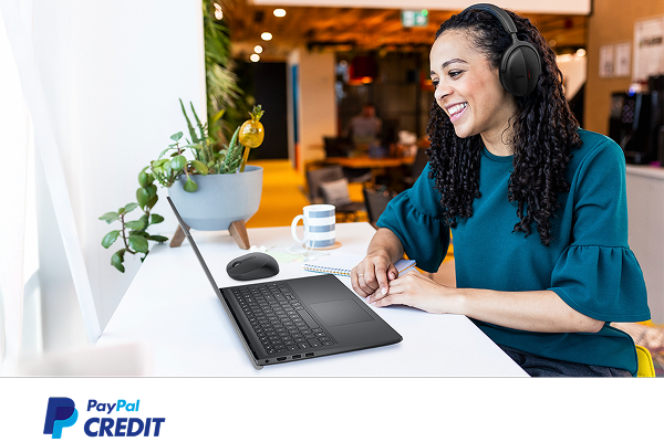 A happy remote worker using a Dell laptop in a cafe.