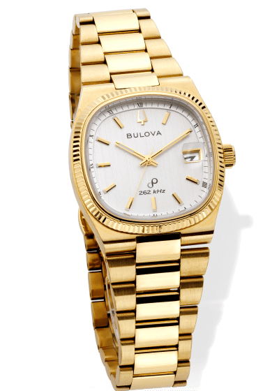Gold Bulova watch with fluted bezel, white dial, and date display.