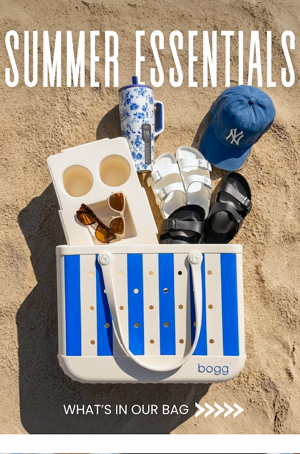 Summer Essentials. See what's in our bag. Image of a blue striped Bogg Bag with Birkenstock sandals, a '47 hat, two pairs of Goodr sunglasses, and a Brumate water bottle.