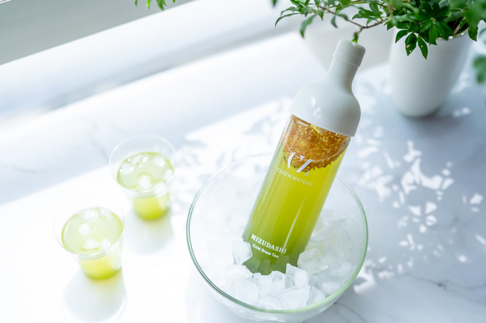 A Cuzen filter-in bottle full of Cuzen Matcha Genmaicha Loose Leaf chills in a bowl of ice.