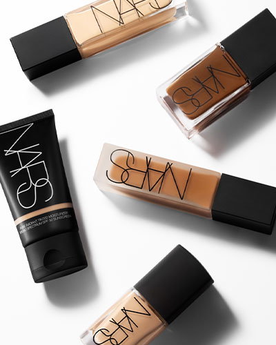 Various NARS makeup products, including foundation and concealer, arranged on a white surface.