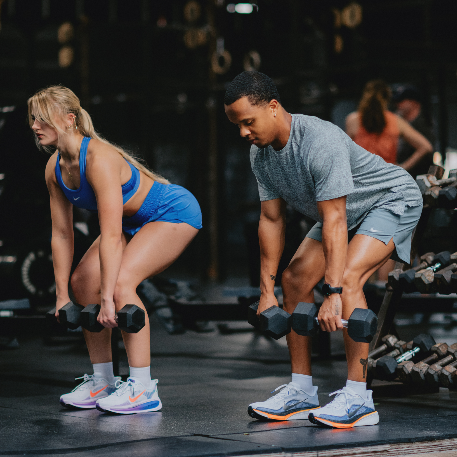 Man and woman lifting weights at the gym