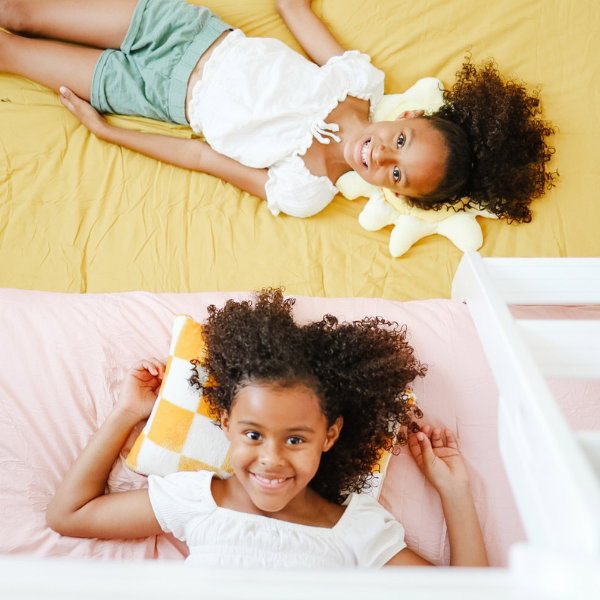 Girls smiling on colorful kid's bunk bed