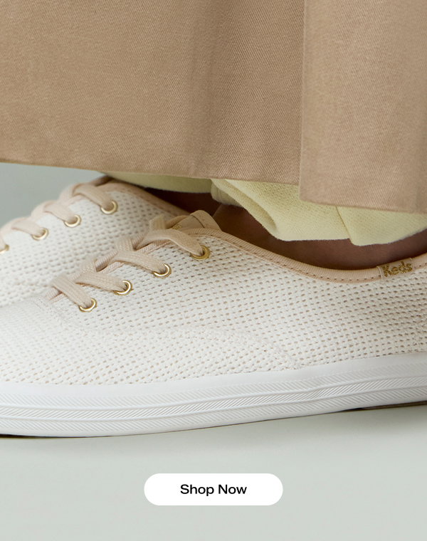 A close-up of the Keds Champion Cotton Mesh Lace-Up in white shown on foot paired with light neutral pants. Shop Now.