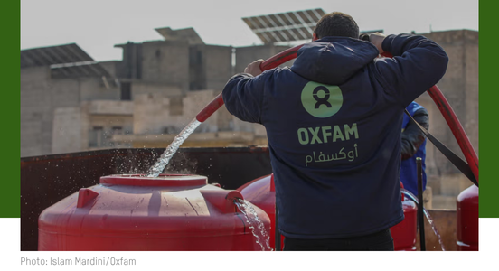 Oxfam staff in Syria fill a water tank (1).png