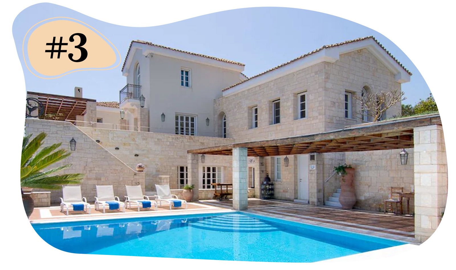 Stone villa featuring a covered patio, outdoor seating, and a pool with nearby lounge chairs.