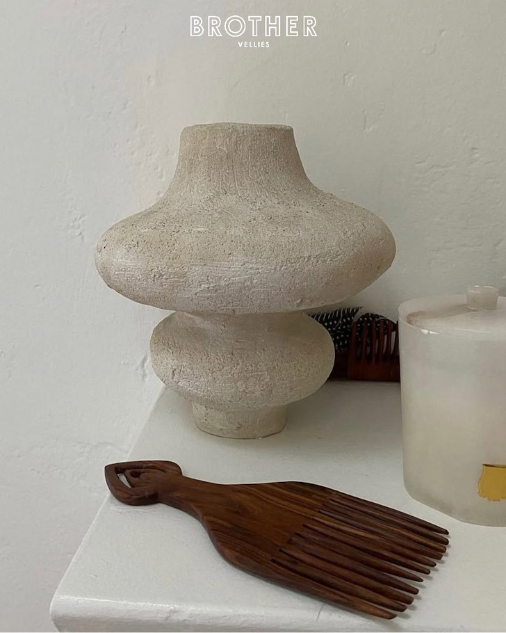 an image of a vase, comb, candle and candle holder on a table