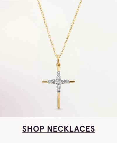 Gold cross pendant featuring a diamond-encrusted center, suspended from chain. Click here to shop necklaces