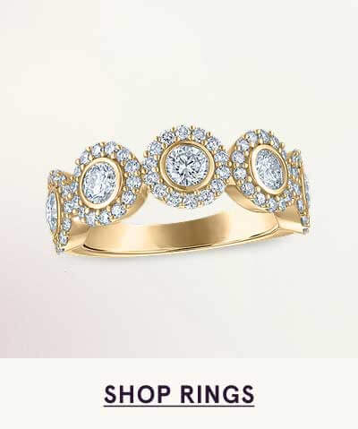 Gold band with five round diamonds encircled by a shimmering halo. Click here to shop rings