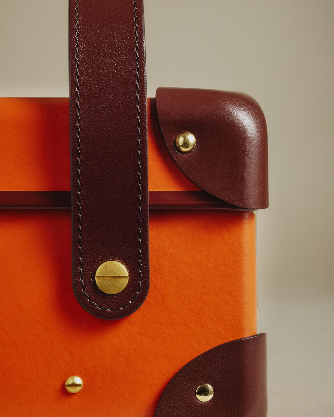 Image of a Globe-Trotter case, orange, close up corner.