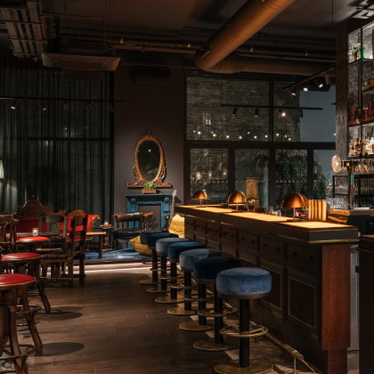 Concrete floors and vintage leather blend with the warmth of walnut and textured fabrics in the Ruby Stella bar