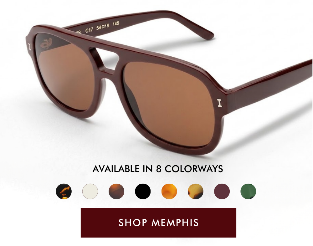 A studio product shot of the Memphis sunglasses, viewed from an angle. The frames feature a deep bordeaux acetate aviator silhouette with a rectangular bridge cutout and dark grey lenses. Below the frames, the text 