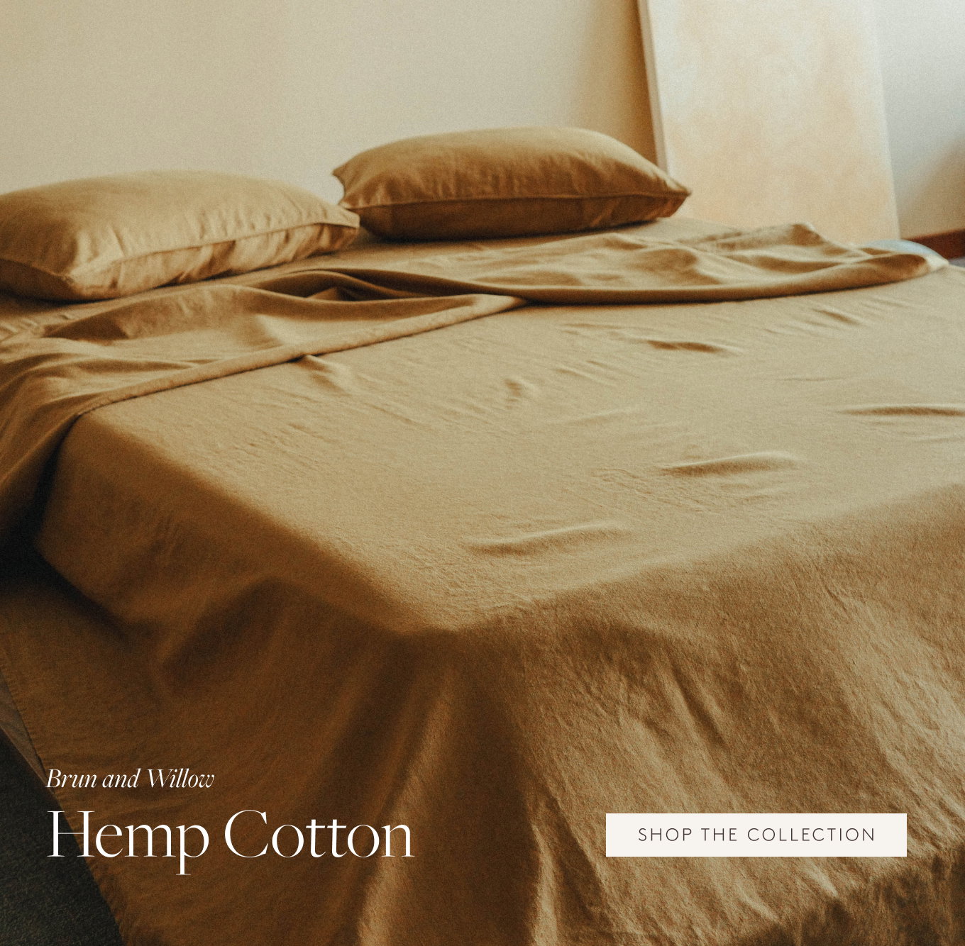 Light brown sheets draped over a bed next to a golden painting