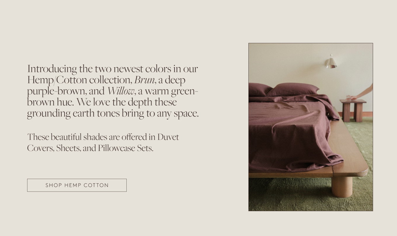 Dark purple sheets on a wooden bed frame 
